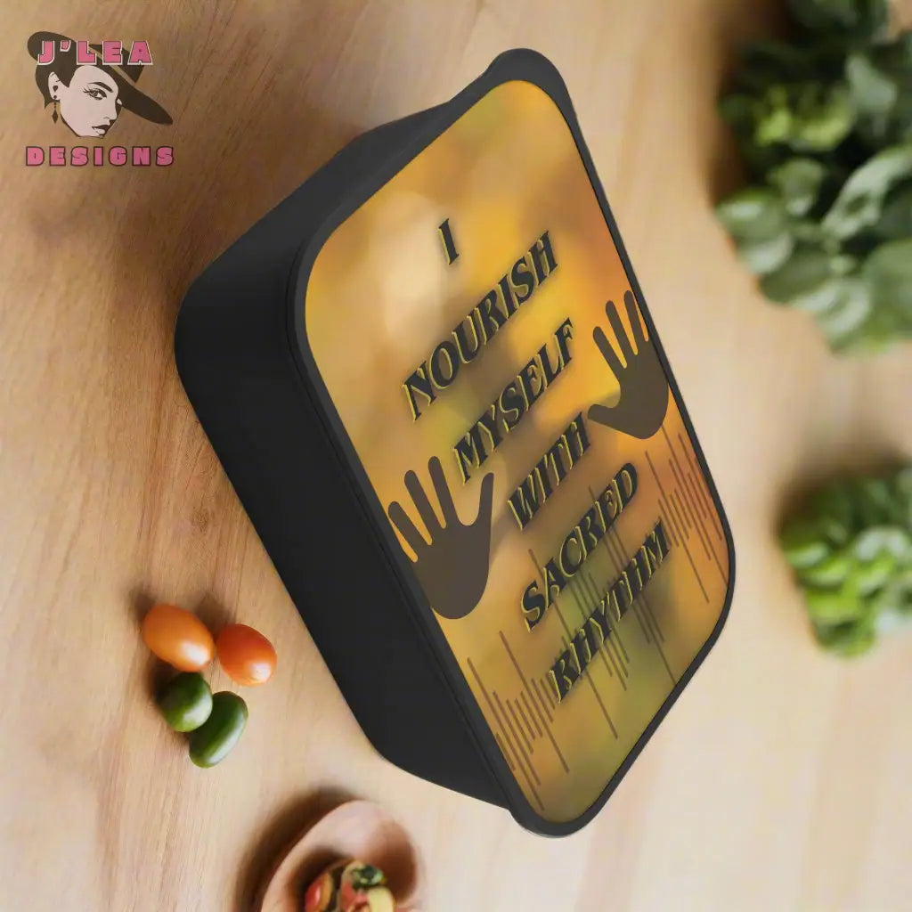 Black bento box with gold lid featuring text and hand icons on a wooden background