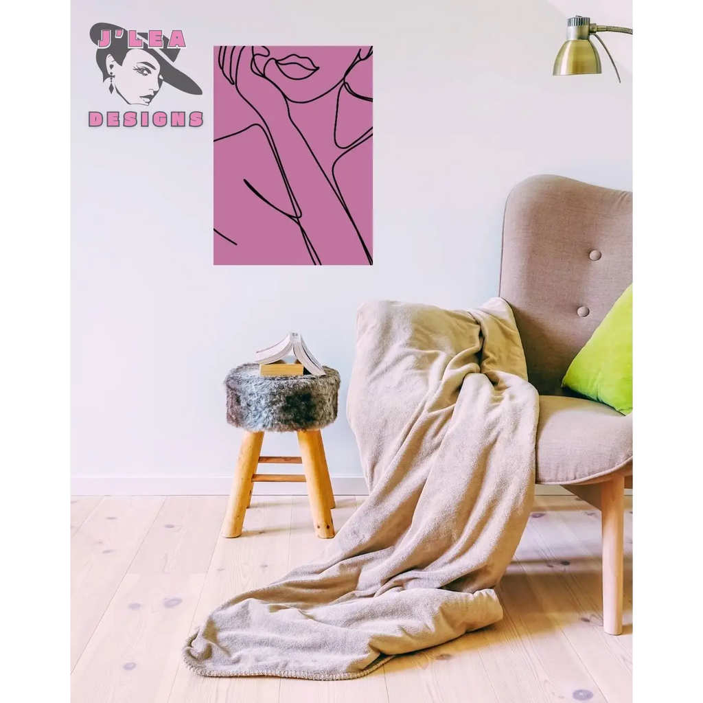 Beige armchair with a blanket draped over it, pink abstract art on the wall, and a small stool.