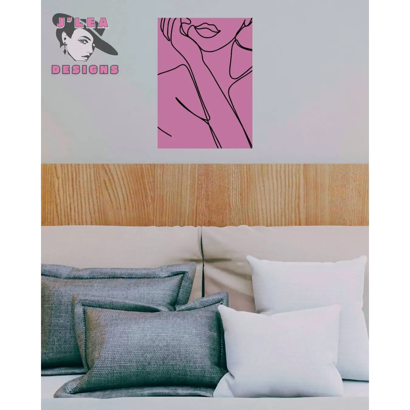 Bed with decorative pillows and a pink wall art piece with black line art on a light gray wall.