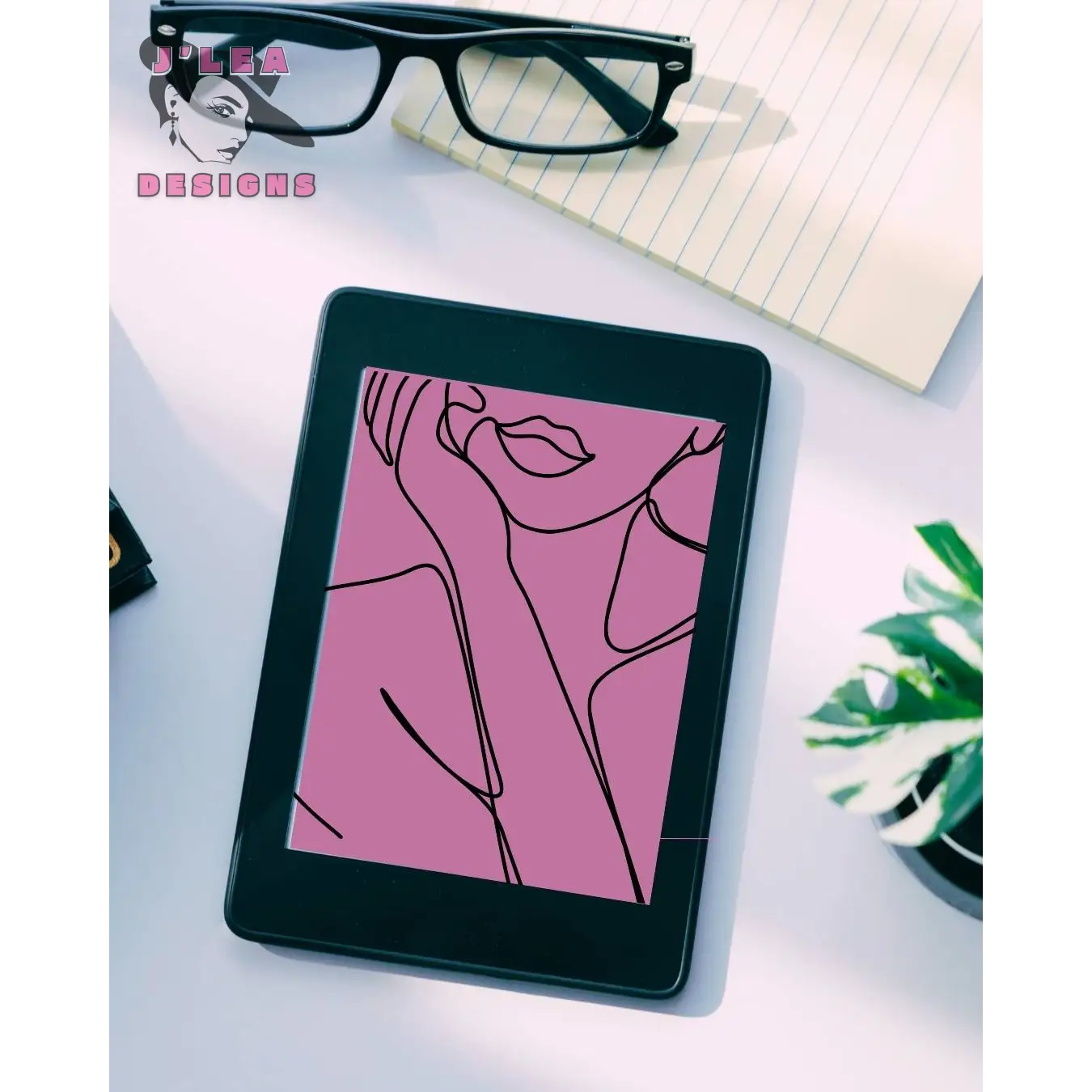 E-reader displaying a pink line art illustration on a desk with glasses and a notebook.